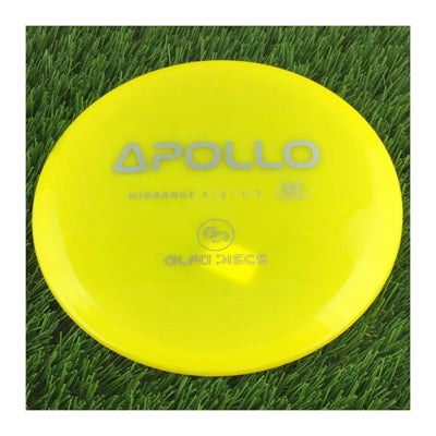 Translucent yellow Alfa Crystal Apollo midrange disc golf disc with a gray "APOLLO" stamp on the top surface.