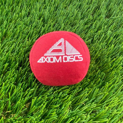 Red Axiom Osmosis Sport Ball Bag with a bright white embroidered Axiom Discs logo on the front surface.