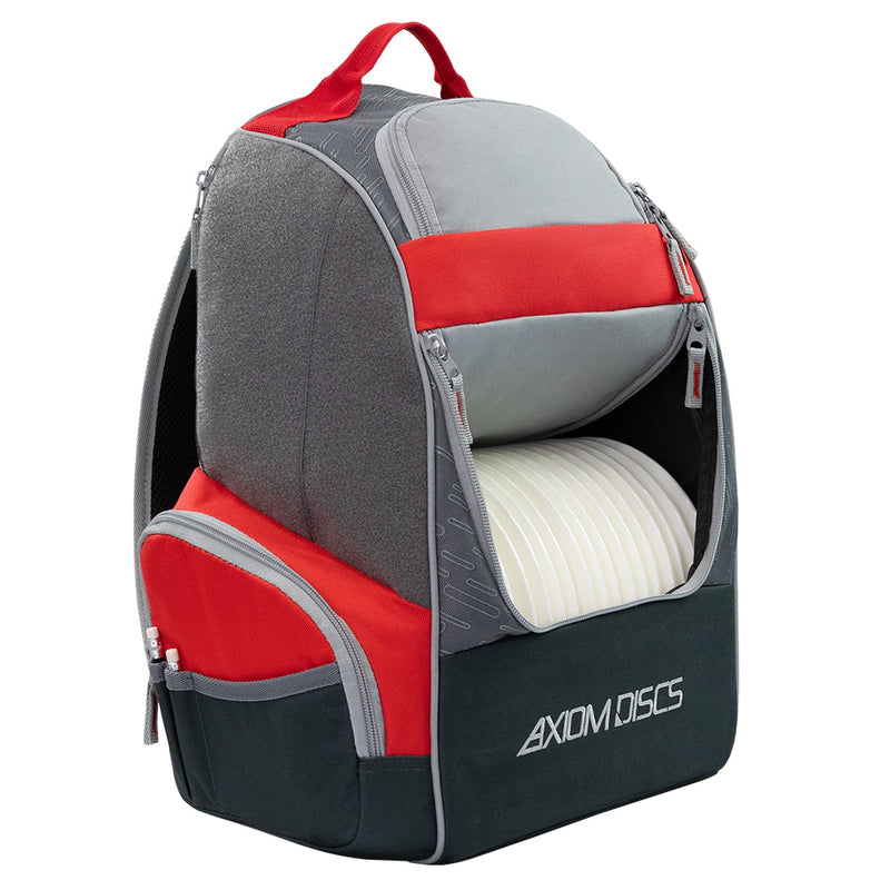 Red, charcoal, and gray Axiom Shuttle disc golf backpack with zippered compartments and white discs visible.