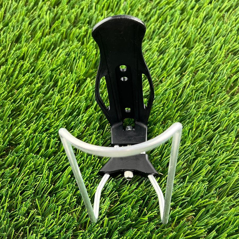 Black zuca cart xl water bottle holder with silver metal basket on artificial green grass.
