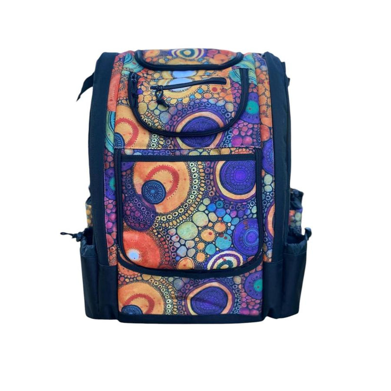 Carbella Designs purple disc golf backpack featuring a multicolored circular pattern, zippered pockets, and side pouches.