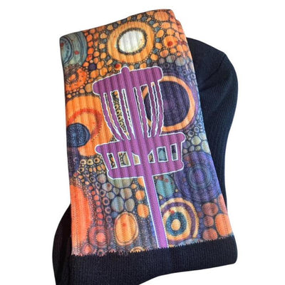 Carbella Designs Tee Box Sox Purple Passion socks feature a bold purple basket on an abstract orange and blue pattern.