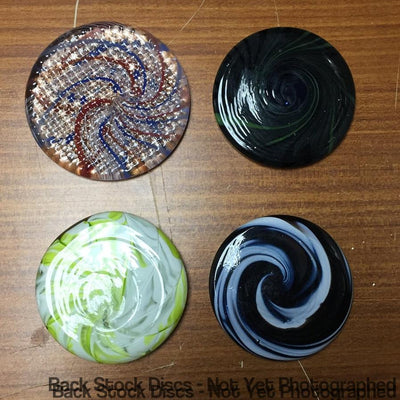 Four round solid glass Charpentier marker discs with unique swirled patterns in black, blue, red, green, and white colors.