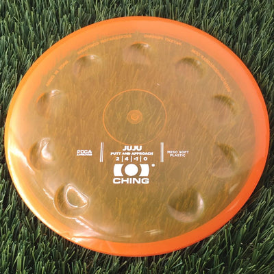 Translucent orange Ching Juju Meso Soft plastic putt and approach disc with raised thumb indentations.