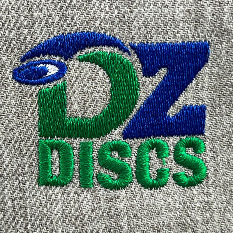 Close-up of a gray textured fabric featuring an embroidered blue, green, and white "dz discs" logo.
