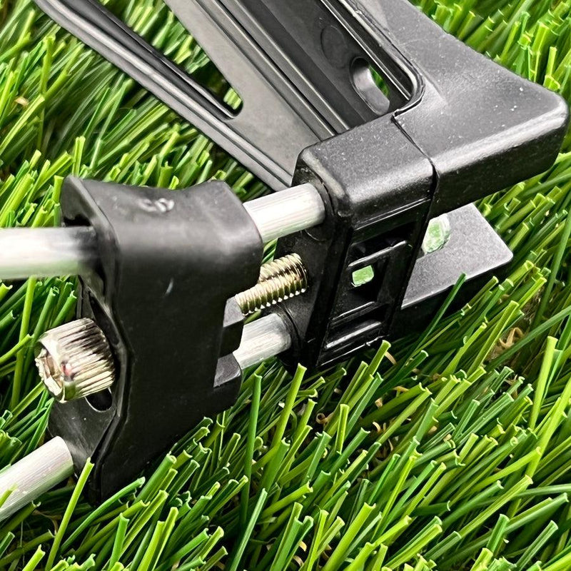 A close-up of a zuca cart water bottle holder with black plastic and shiny bolts on green turf.