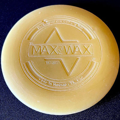 Circular pale yellow dg Max Wax mini disc golf grip wax with an embossed logo featuring "MAX WAX EST 2020".