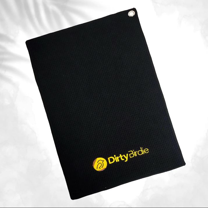 Black Dirty Birdie disc golf towel features a yellow logo and a silver grommet in the corner.