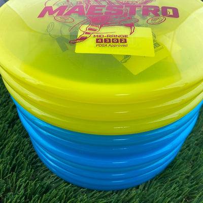 Stacked Discmania Active Premium Maestro mid-range discs, with bright yellow on top and blue plastic on the bottom.