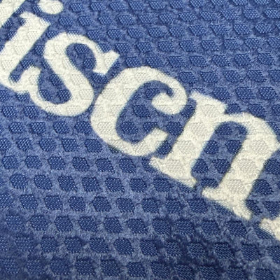 Close up of a blue Discmania Sportsack featuring absorbent waffle weave fabric and the white Discmania bar logo.