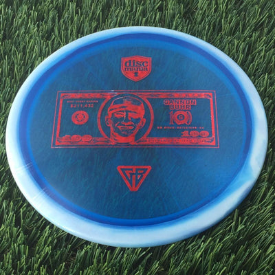 Translucent blue Discmania Horizon C-Line Metal Flake FD3 disc with a red Gannon Buhr dollar bill stamp.