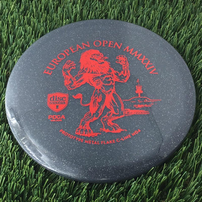 Translucent grey Discmania Metal Flake C-Line MD4 disc with a red European Open MMXXIV lion stamp.