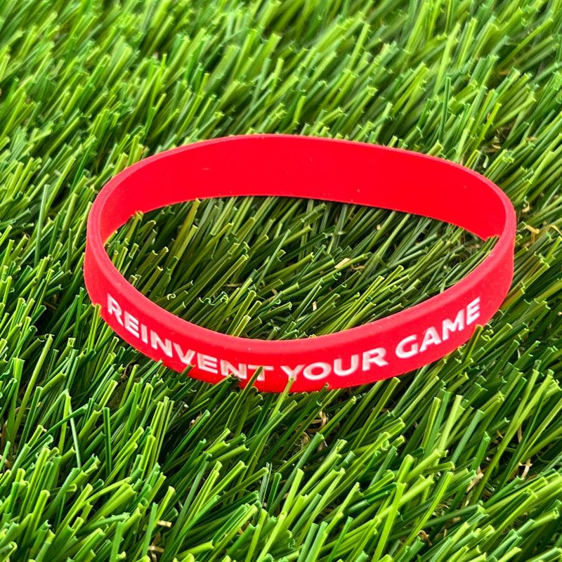 Red Discmania "REINVENT YOUR GAME" silicone wristband, perfect for showing your disc golf spirit.