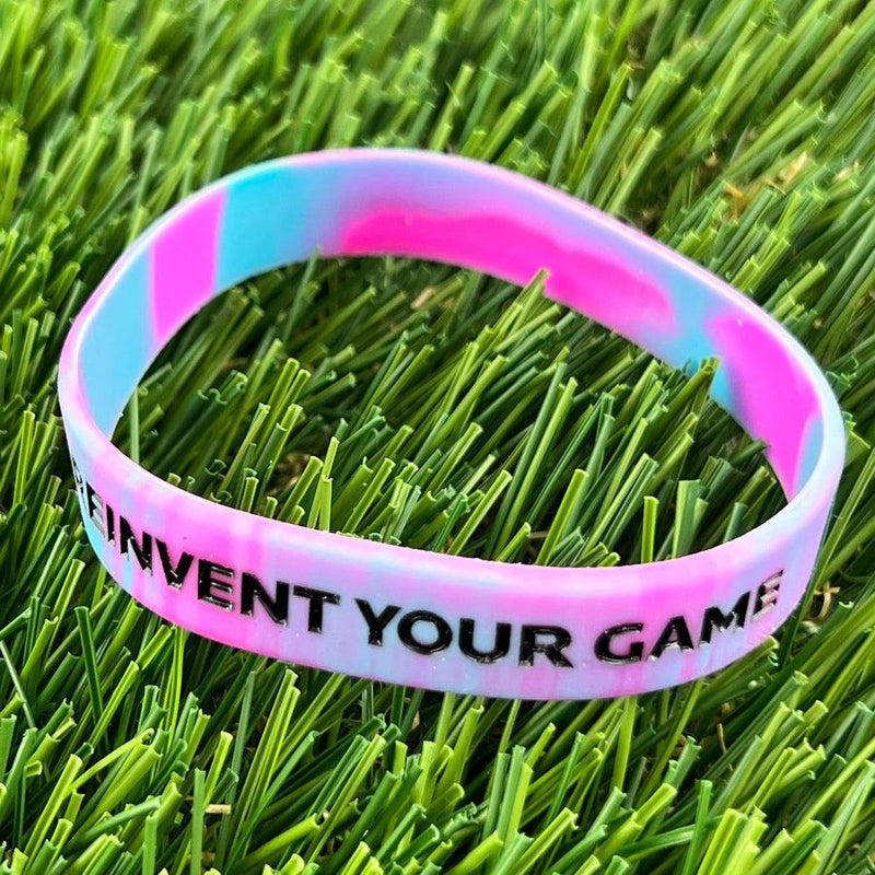 Discmania ReInvent Your Game wristband with a swirled pattern of pink and light blue on the silicone band.