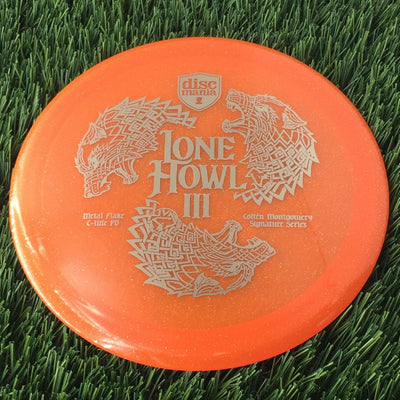Translucent orange C-Line Metal Flake Discmania PD disc with a silver Lone Howl III Colten Montgomery Signature Series stamp.