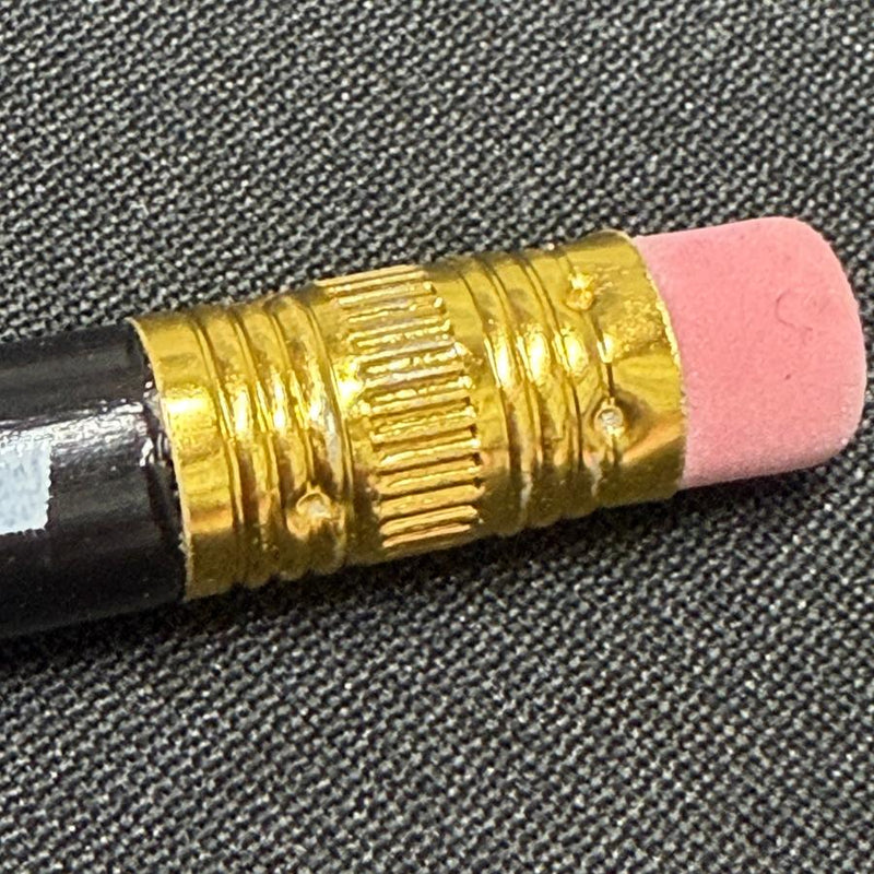 Discraft black score keeping pencil featuring a shiny gold ferrule and a pink eraser.