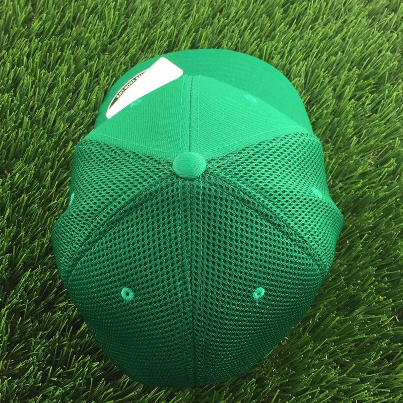 Green mesh back Flexfit curved bill hat with a solid green front panel and small vent holes.