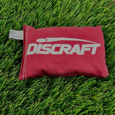Crimson red Discraft Sportsack with a white logo and visible stitching along the edges, and a Grip Co. tag.