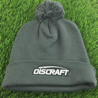 Dark gray knit Discraft embroidered logo cuff pom beanie with a matching gray pom on top.
