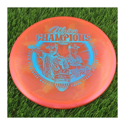 Translucent red Discraft Elite Z Swirl Buzzz disc golf disc featuring blue 2022 Champions Cup stamp.