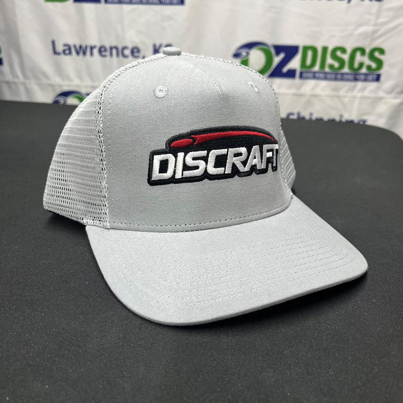 Gray curved bill mesh snap hat with a black, red, and white Discraft embroidered logo on the front panel.