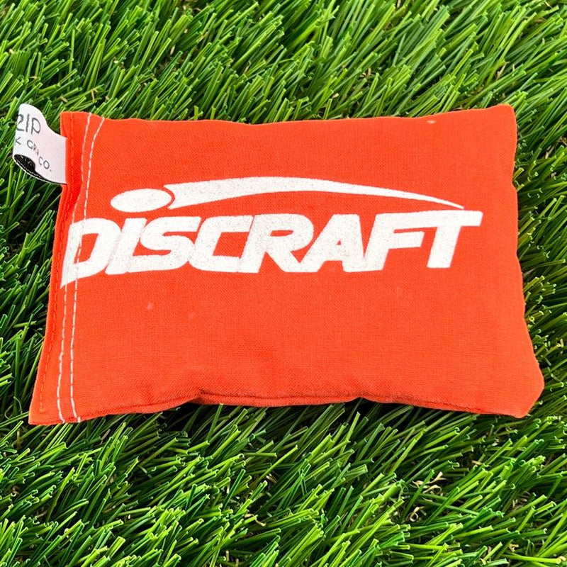 Orange fabric Discraft Sportsack with a prominent white logo and a small white Zip Chico tag.