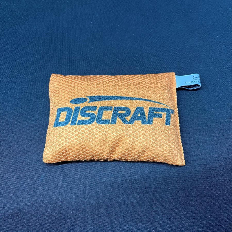 Orange Discraft silky feel waffle sportsack with a blue logo printed across the front and a small blue tag.