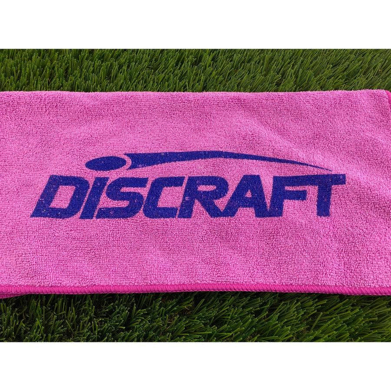Bright pink Discraft microfiber golf towel featuring a prominent dark blue printed logo.