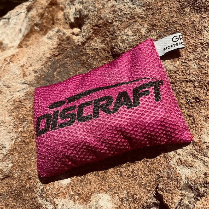 Bright pink Discraft Silky Feel Waffle Sportsack with a black Discraft logo across the front.