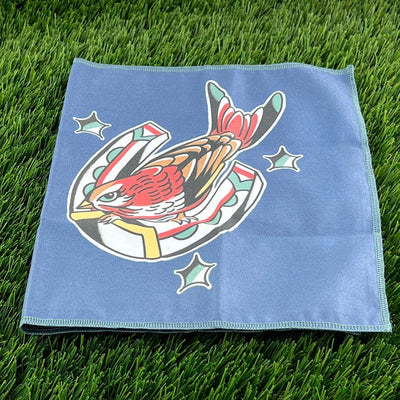Disctroyer Nightjar microfiber towel in blue with a colorful bird on a horseshoe design framed by stars.