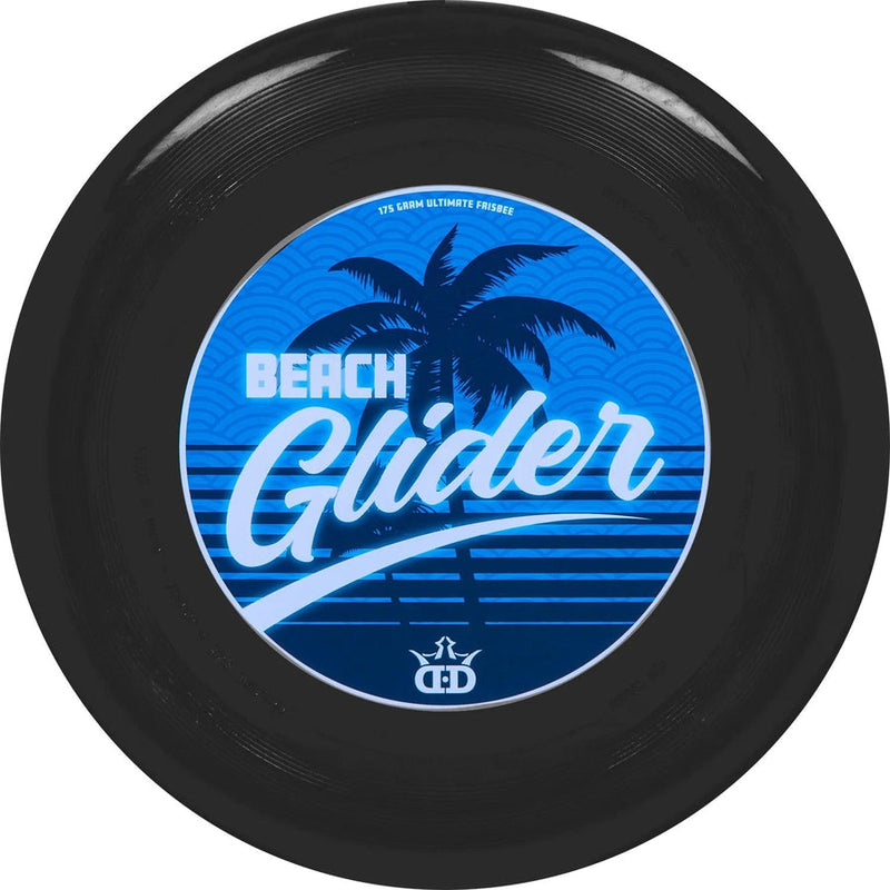 Black Dynamic Discs Beach Glider ultimate frisbee with a blue palm tree and wave graphic on the underside.