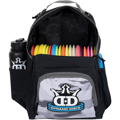 Black Dynamic Discs Cadet Backpack with a gray camouflage pocket, filled with colorful discs and an attached water bottle.
