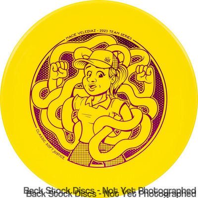 Yellow Dynamic Discs Classic Soft Justice Macie Velediaz 2023 Team Series disc with purple cartoon graphic.