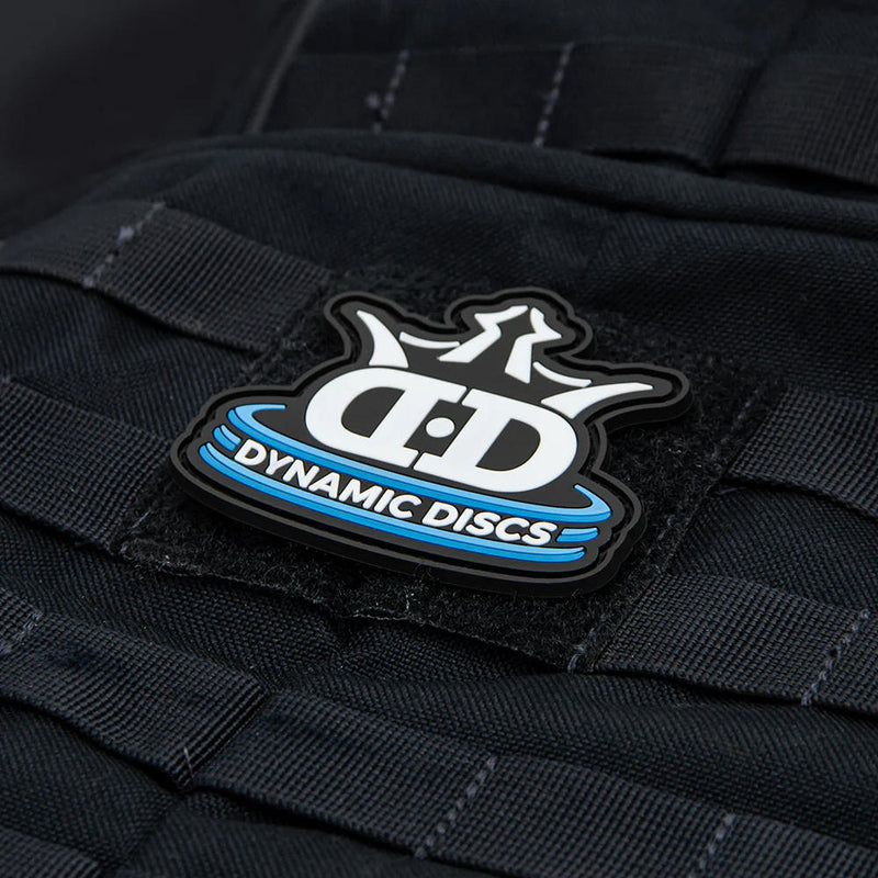 Black Dynamic Discs collector patch with a stacked logo featuring white lettering, blue accents, and a black border.