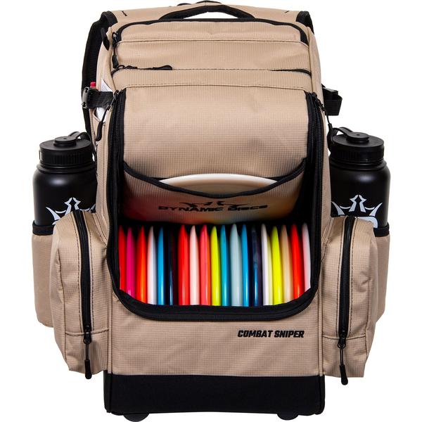 Tan Dynamic Discs Combat Sniper backpack disc golf bag with colorful discs and two black water bottles.