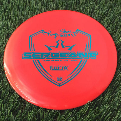 Solid red Dynamic Discs Fuzion X Blend Sergeant with a blue-teal Paige Shue 33833 Team Series V2 2021 stamp.