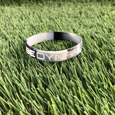 Gray camo Dynamic Discs "BE DYNAMIC" wristband featuring white raised lettering and a durable silicone construction.