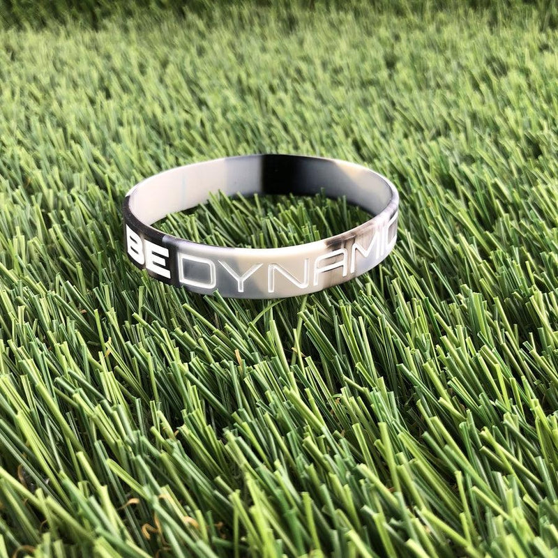 Gray camo Dynamic Discs "BE DYNAMIC" wristband featuring white raised lettering and a durable silicone construction.