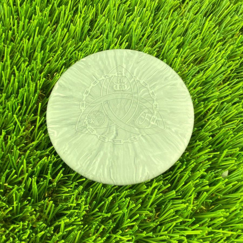 Light gray Dynamic Discs Mini Judge with an engraved Trilogy logo featuring a chain link border and crown.