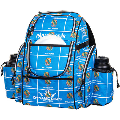Blue Static Discs Paratrooper disc golf bag with an Oklahoma state flag pattern and two black water bottles.