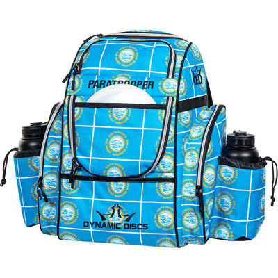 Dynamic Discs Paratrooper backpack bag with a blue and white grid pattern featuring many Mount Rushmore logos.