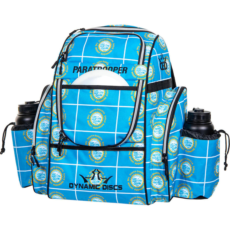 Dynamic Discs Paratrooper backpack bag with a blue and white grid pattern featuring many Mount Rushmore logos.