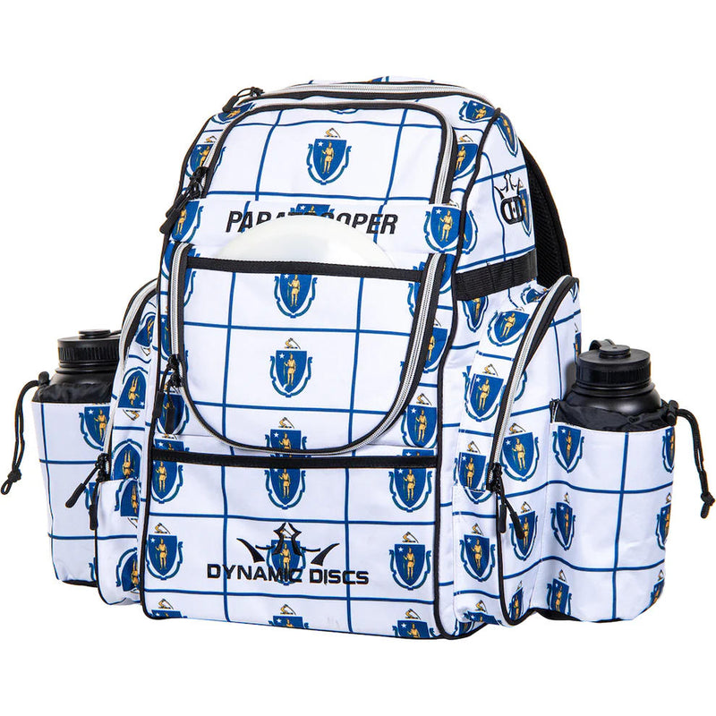White Dynamic Discs Paratrooper disc golf bag with a blue state seal pattern and two black water bottles.