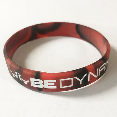 Red and black camouflage-patterned silicone Dynamic Discs wristband with white embossed "BE DYNAMIC" lettering.