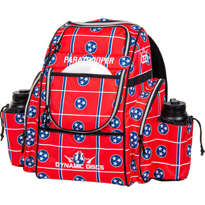 Red Dynamic Discs Paratrooper disc golf bag with a Tennessee flag pattern, bottle holders, and zippered compartments.