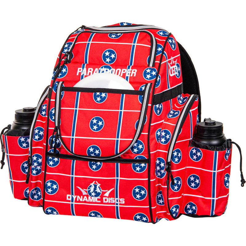 Red Dynamic Discs Paratrooper disc golf bag with a Tennessee flag pattern, bottle holders, and zippered compartments.
