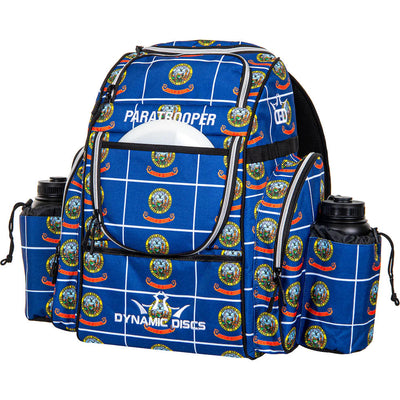 Royal blue Dynamic Discs Paratrooper backpack with a white grid pattern and circular state seal logos.