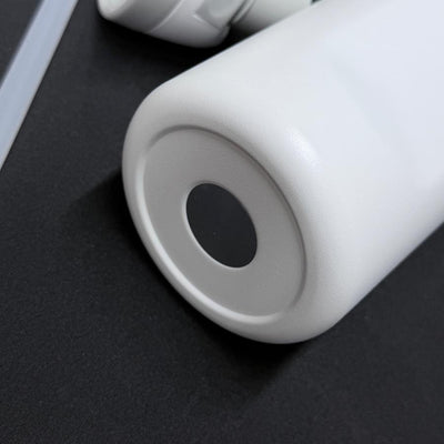 Bottom view of a white insulated Dynamic Discs water bottle with a textured finish and a black anti-slip pad.