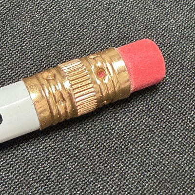 White Dynamic Discs pencil with a brass ferrule, a textured edge, and a vibrant pink eraser stub.