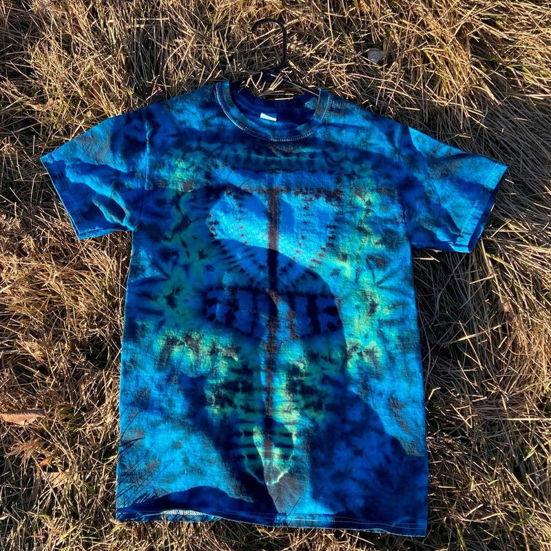 A vibrant blue and teal tie-dye t-shirt featuring a dark, abstract circular design on the front.